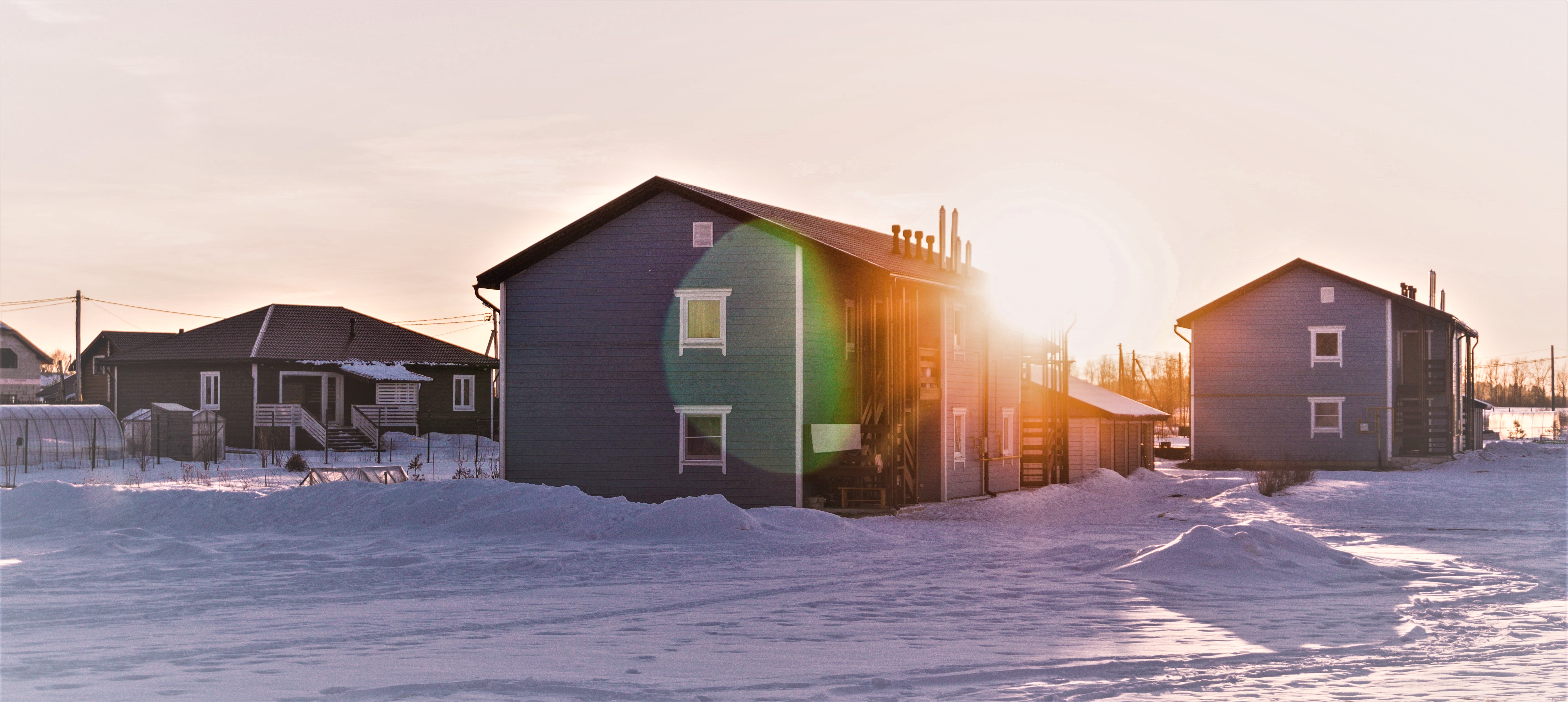 Bild på ett bostadshus med snö och fint väder