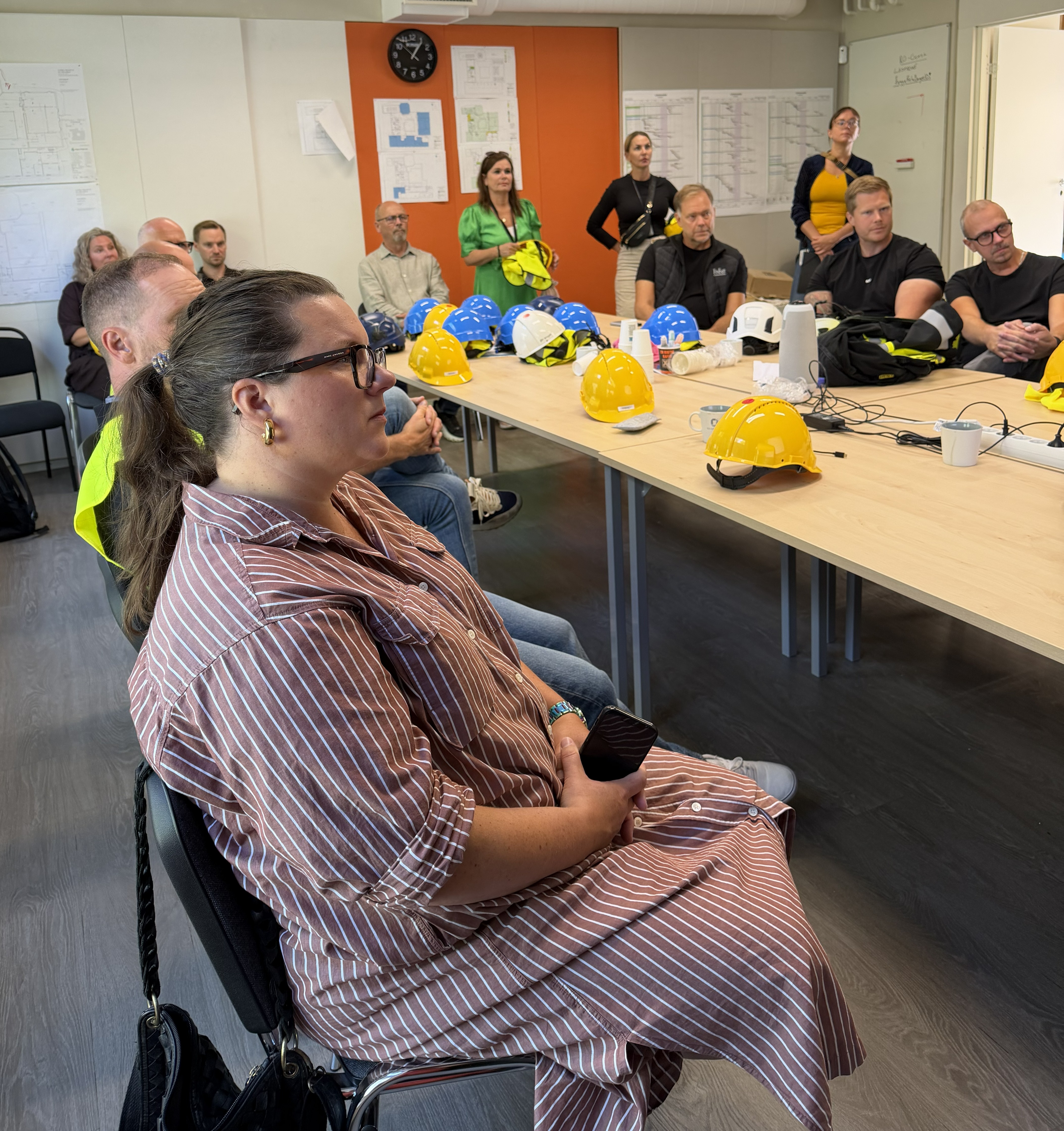 Deltagarna runt ett konferensbord. På bordet ligger skyddshjälmar.
