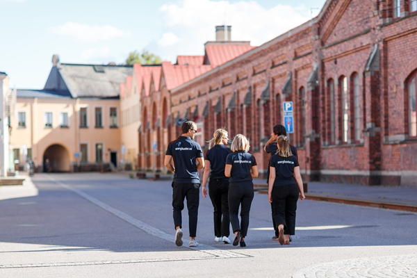 Fyra personer går omkring på ett gammalt industriområde