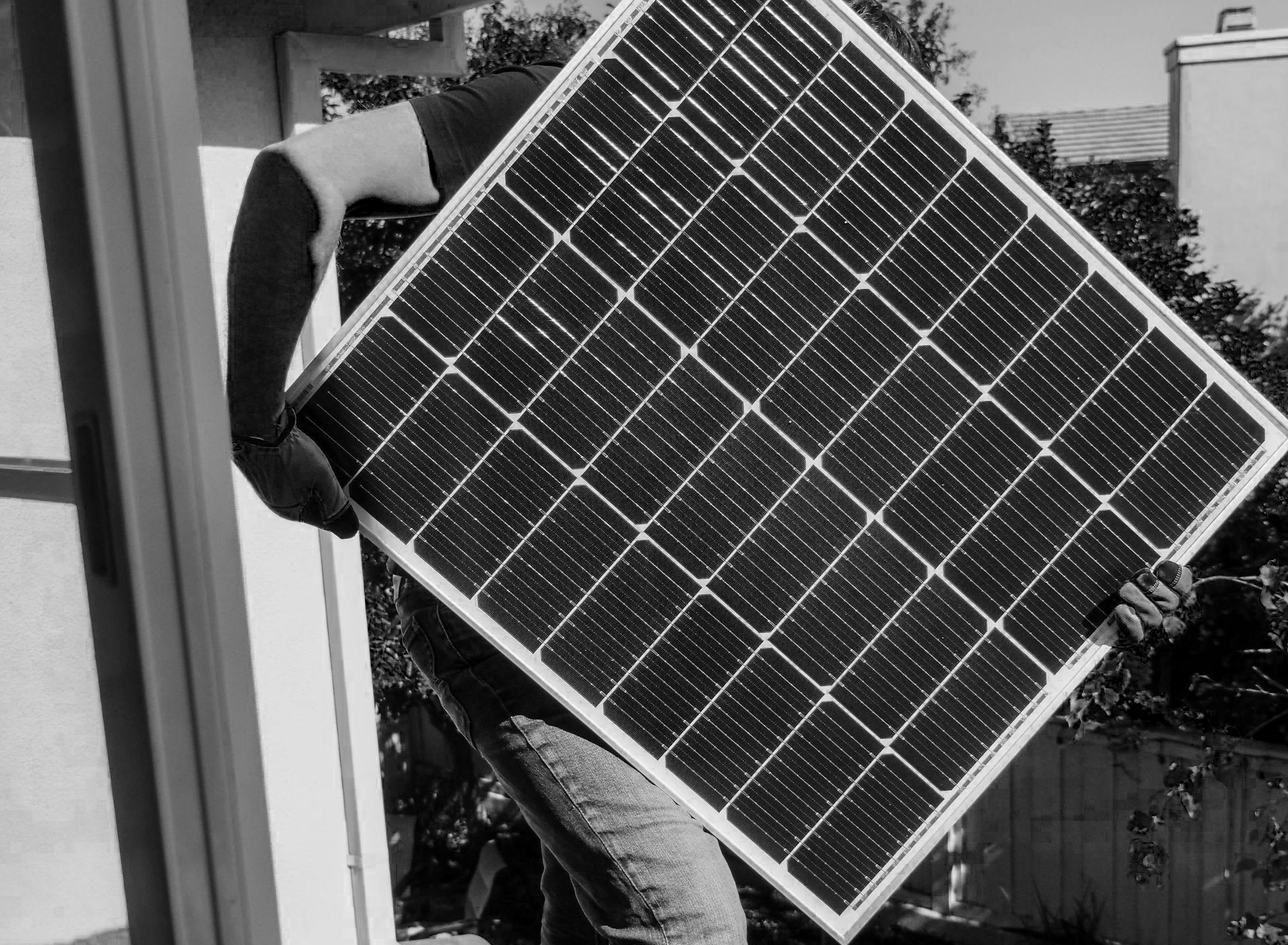 Man som bär en skica med solceller. Det är nästan bara skivan som syns