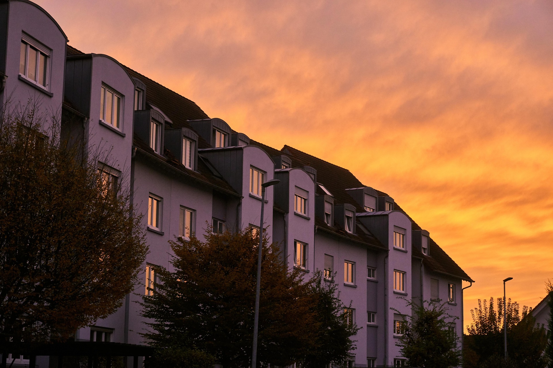 Rosa hyres hus i solnedgång med orangerosa himmel