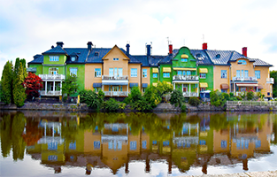 Gula och gröna villor vi den år som speglar sig i vattnet