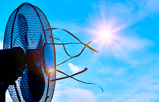 En bordfläkt som snurrar med en himmel som bakgrund
