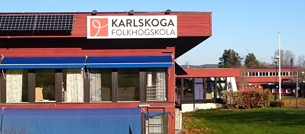 Skylt med texten Karlskoga folkhögskola på en husfasad